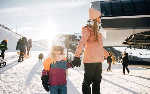 Les plaisirs de l'hiver pour petits et grands Femme tenant un enfant par la main